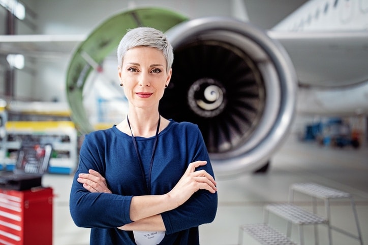 Woman arms crossed in front of jet engine